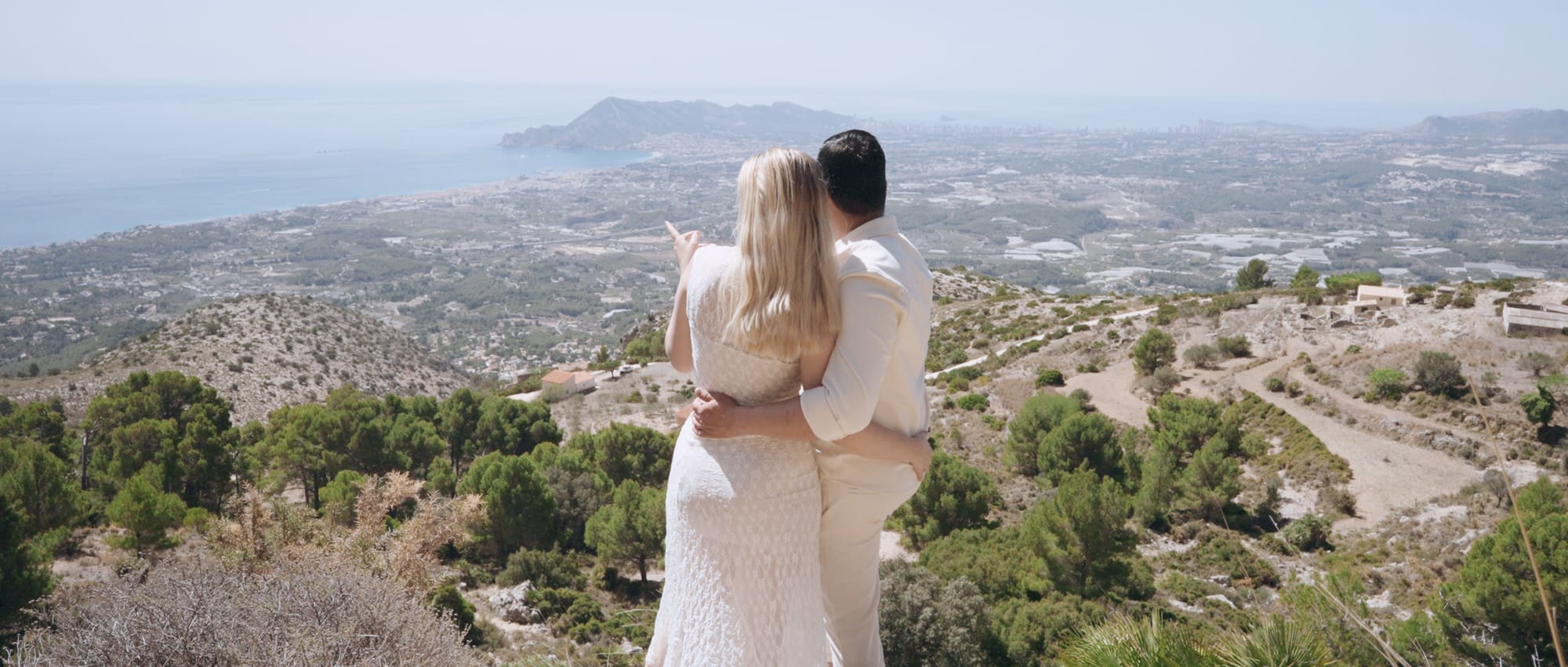 Couple holding each other at a scenic overlook on their elopement day captured by a professional elopement videographer and planned by an experienced elopement planner.