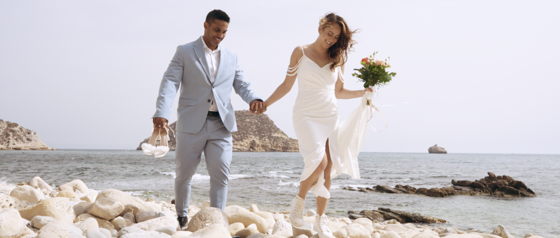 Speaking vows during their hiking and beach elopement in Spain with view of the mediterranean sea.