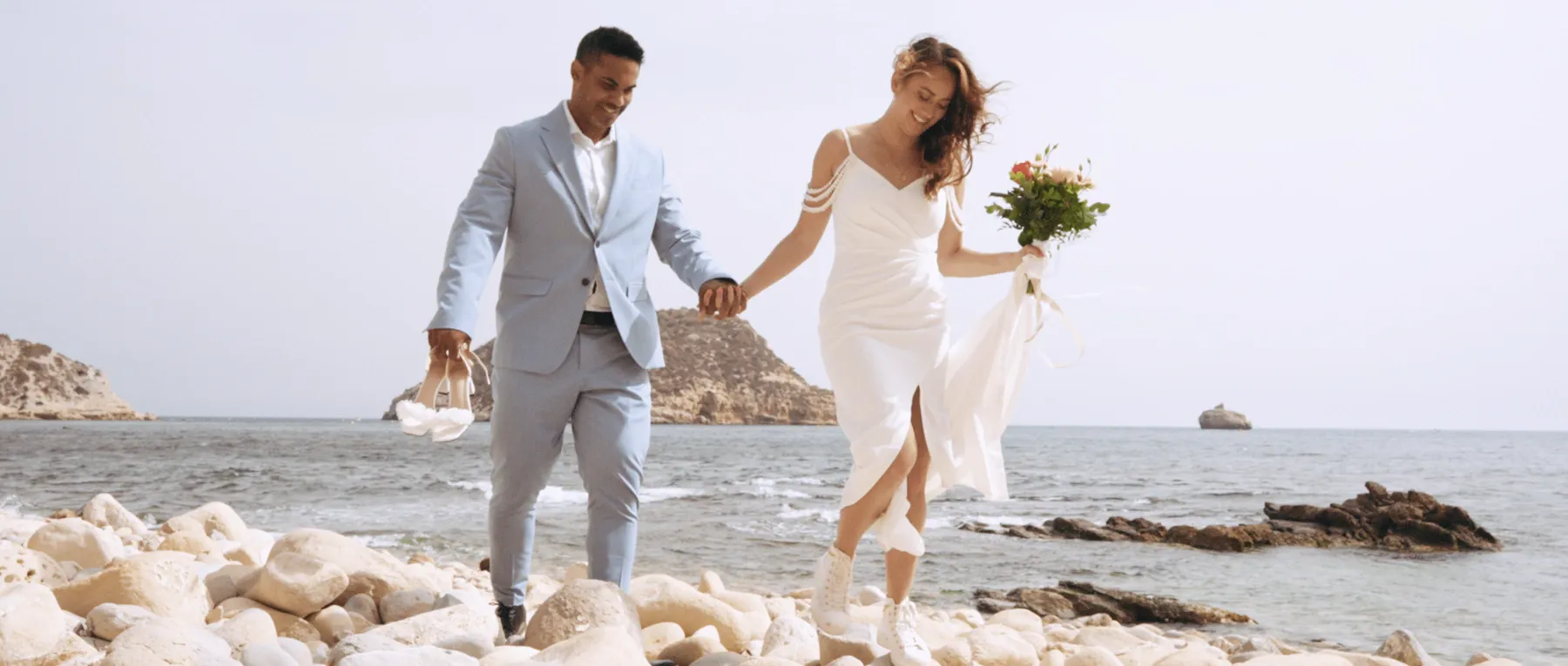 Speaking vows during their hiking and beach elopement in Spain with view of the mediterranean sea.